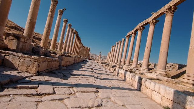 Walking on a paved road surrounded by old columns in Jerash with a rotating effect