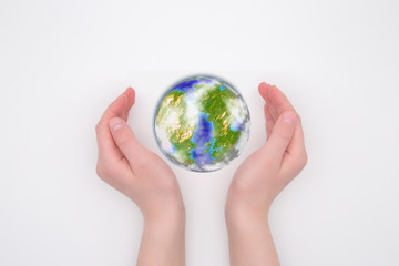 Children's hands hug the globe. White background. Planet Earth care concept.