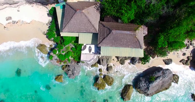 Flying above luxury secluded beachfront resort with ocean view on Bali island with sandy coastline at Nusa Dua beach line,Indonesia