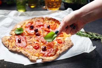 Thin crust pizza. A plate with an appetizing dish. Application suggestion. Culinary photography, food stylization.
