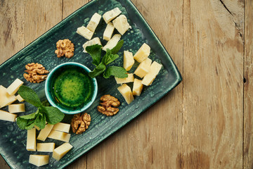 Antipasto - a cheese plate. Different, homemade cheeses on a ceramic plate - brie, camembert, Dutch with honey and nuts. Wine appetizer.