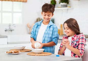 Little brother helping sister on breakfast