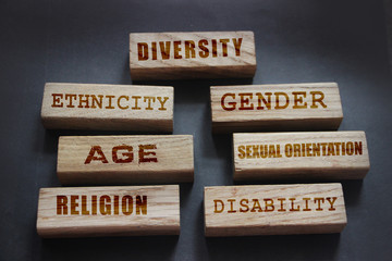 Diversity ethnicity gender age sexual orientation religion disability words written on wooden...