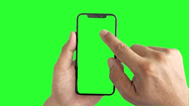 Man's hand holding a black smartphone with green screen slide up and slide down display, Man using mobile phone with chroma key touch display on green background.