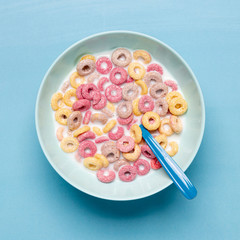 Colourful cereal in blue bowl and spoon