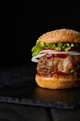 delicious burger on dark wooden surface isolated on black