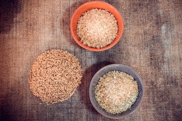 Three bowls of white rice on a burlap background, top view