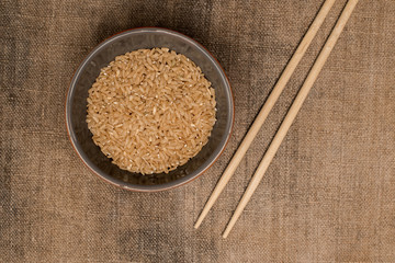 Two chopsticks and a bowl of rice, top view. Asian cuisine