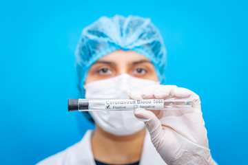 Female doctor wearing respirator mask holding empty test tube for 2019-nCoV analyzing. Novel...