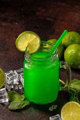 Delicious icy cocktail with fruits on dark grounge background. Healthy colorfull fruit shakes with ice on textured table.