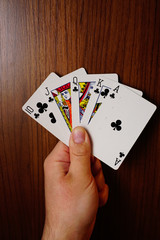 Poker cards with assorted combinations in man hand close up and isolated background