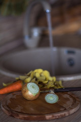 Onions, carrots and potato wraps on a wooden cutting board. Prepared concept for cooking soup at home. Ingredients for making soup at home.