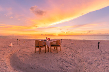 Romantic dinner on the beach with sunset. Couple honeymoon or anniversary dinner at the beach....