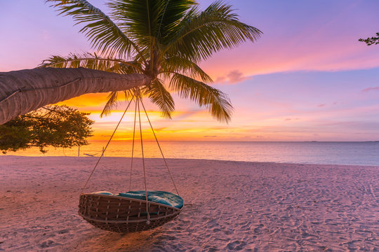 Tropical beach sunset as summer landscape with luxury resort beach swing or hammock and white sand and calm sea for sunset beach landscape. Tranquil beach scenery vacation and summer holiday concept.