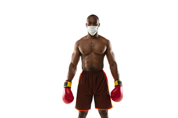 Beat off the virus. African-american boxer in protective mask, gloves. Prevention against pneumonia. Still active while quarantine. Chinese coronavirus treatment. Healthcare, medicine, sport concept.