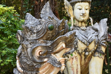 Obraz premium Dragon Statue Close-up in Foreground, Lion Buddha in Background, Pha Lat Temple, Chiang Mai