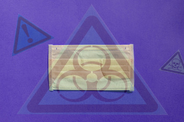 yellow medical mask on a bright purple background transparent hazard and biological hazard signs