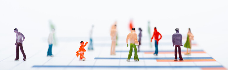 Concept of equality with plastic people figures on surface with graphs isolated on white, panoramic shot