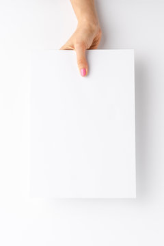 Female hand holding blank white paper sheet. Mock up
