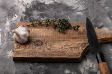 Composition with a garlic and knife on a textured plastered surface