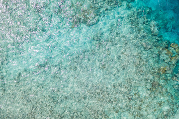 Amazing tropical nature. Aerial view of the tropical sea surface with coral reefs on the bottom