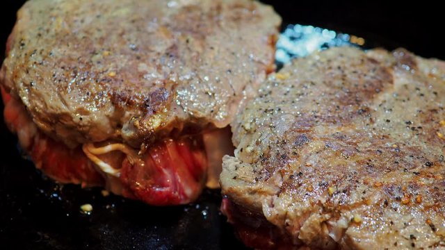 Close up shot of frying the delicious Prime Rib Eye Cap on a cast iron pan