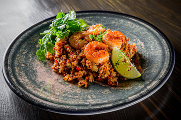 Fried rice with shrimp and vegetables in plate on wooden table background