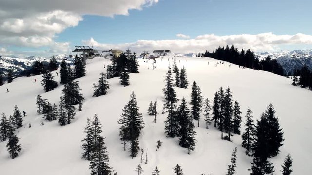 Kitzb&uuml;hler Alpen, tourists on winter vacation skiing downhill at the famous ski resort in Austria, at a clear sunny day