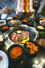 Korea bbq style restaurant  with meat and vegetable side diesh.