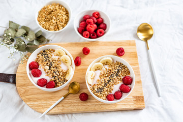 Yogurt with granola, chia seed, raspberry and banana, healthy breakfast concept,  top view