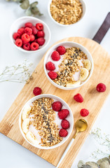 Yogurt with granola, chia seed, raspberry and banana, healthy breakfast concept,  top view