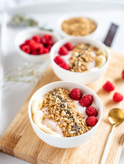 Yogurt with granola, chia seed, raspberry and banana, healthy breakfast concept,  top view