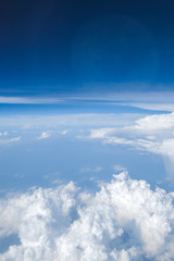 Fototapeta na wymiar Blue sky with white curly fluffy clouds.