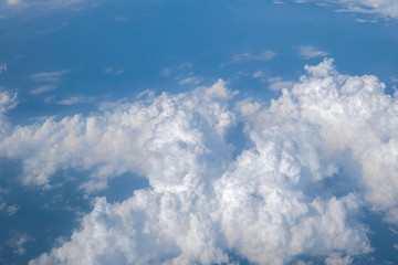 Blue sky with white curly fluffy clouds.