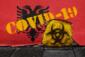 Flag of Albania on the wall with covid-19 quarantine symbol on it. 2019 - 2020 Novel Coronavirus (2019-nCoV) concept, for an outbreak occurs in Albania.