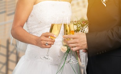 Young beautiful couple in the wedding day with glasses of champagne