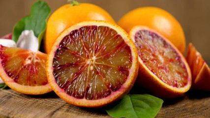 bloody juicy orange turning on wooden board