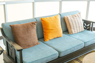 empty sofa and chair with pillows