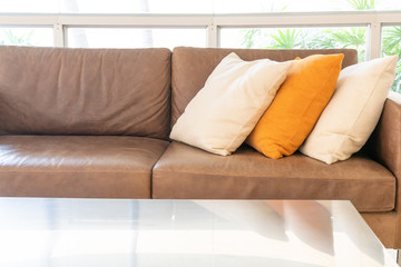 empty sofa and chair with pillows