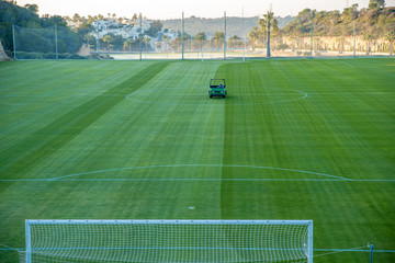 Maintaining a football field using a motorized lawn mower
