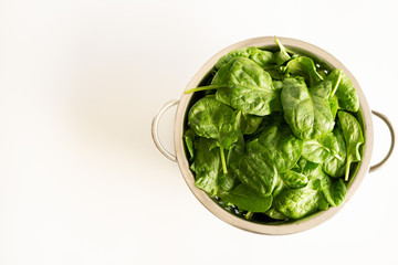Fresh green spinach bundle isolated in bowl on white. top view. Vegetable banner or heading design....