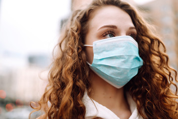 Girl in protective sterile medical mask on her face on the street. Woman, wear face mask, protect...