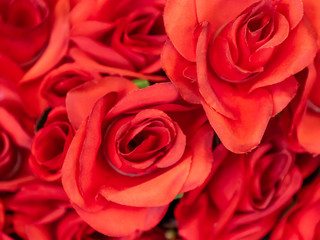 Close up imitation or artificial red rose flower background. Selective focus.