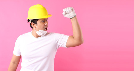 Asian man Industry worker or engineer working an architect builder Happy excited raising his fists  on pink background in studio With copy space,concept international labour day.