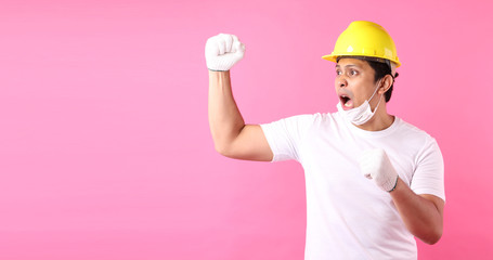 Asian man Industry worker or engineer working an architect builder Happy excited raising his fists  on pink background in studio With copy space,concept international labour day.