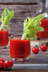 Glass of tomato juice on a wooden table, on a wood background, fresh drink