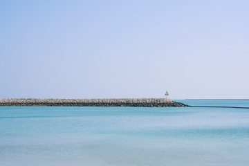 Rocks pier on the sea water over blue sky background, Bahrain.