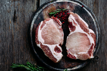 Raw meat on a cutting board on the kitchen table. Pork steak. Country style.
