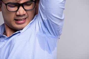 Close up asian man with hyperhidrosis sweating. Young asia man with sweat stain on his clothes...