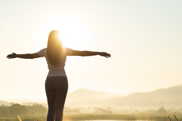 Silhouette of happy woman spreading arms and watching the mountain. Travel Lifestyle success...